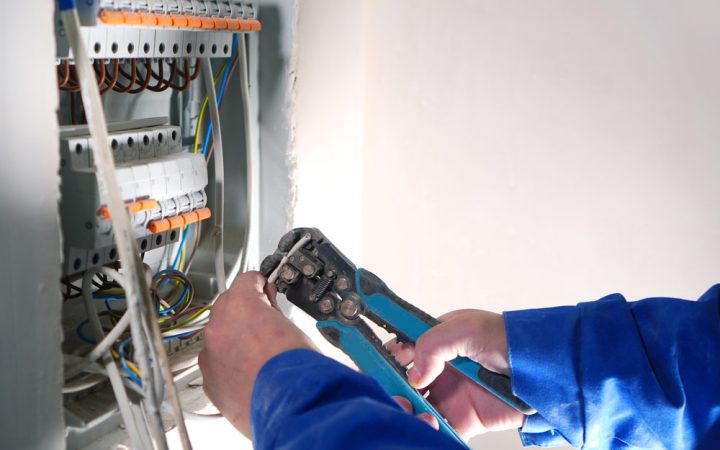 An electrician using specialized tools to replace or repair a circuit breaker, ensuring safe and functional electrical systems.