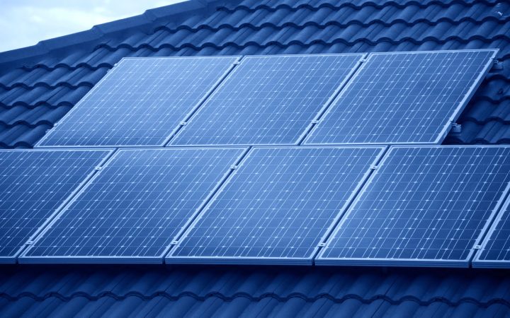 Rows of solar panels installed on a residential roof, highlighting renewable energy solutions for homes.